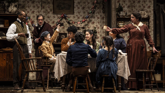 The Cratchits toast to Scrooge while he looks on